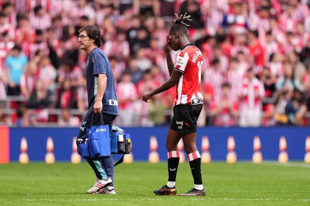 Nico Williams covers his face with his right hand as he follows a member of Athletic Club's medical staff off the field during the home defeat to Valencia on Sunday