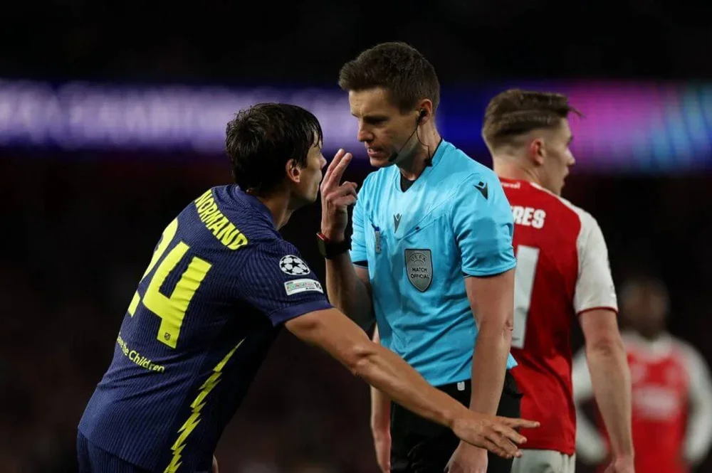Referee Daniel Siebert talks to Atletico Madrid's Spanish defender Robin Le Normand